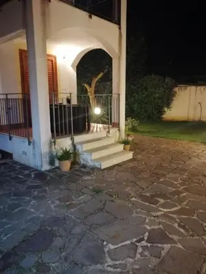 a house with a staircase leading to a porch at night at Villa Cavalluccio Marino con piscina idromassaggio in Carini