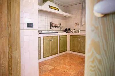 a kitchen with green cabinets and tile walls at Solemar Sicilia - Villa Anastasia in Ficarazzi
