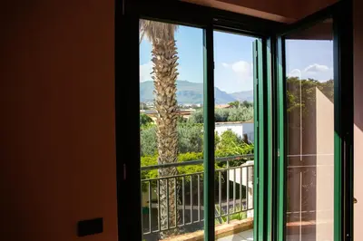 a palm tree is seen through a window at Solemar Sicilia - Villa Anastasia in Ficarazzi