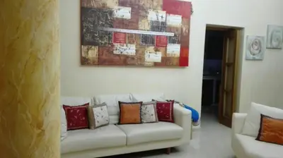a living room with a white couch with colorful pillows at Carini Luxury Apartment vicino aereoporto e al mare in Carini