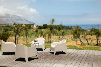 a group of white chairs and a table on a patio at Villa NATURE ZAGARA SCOPELLO ZINGARO in Castellammare del Golfo