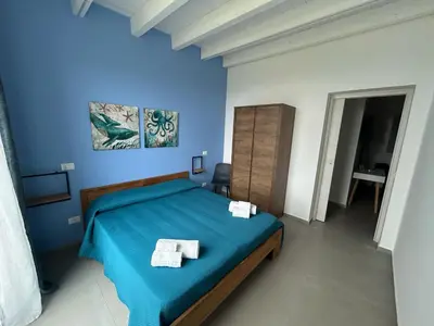 a blue bedroom with a bed with two towels on it at Villa NATURE ZAGARA SCOPELLO ZINGARO in Castellammare del Golfo