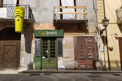 a building with a green door and a sign on it at Casa vacanza Terra Mare in Castellammare del Golfo