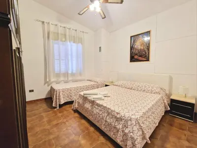a bedroom with two beds and a window at Villa Mazzamuto in Altavilla Milicia
