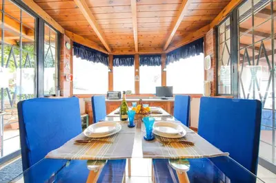 a dining room with a table and blue chairs at Villa Rosa Bianca in Palermo
