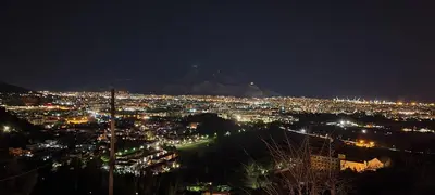 a city at night with a mountain in the background at Villa Rosa Bianca in Palermo