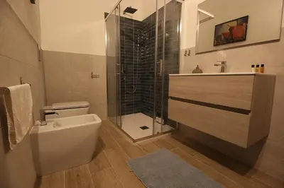 a bathroom with a shower and a toilet and a sink at Villa Rosa Bianca in Palermo