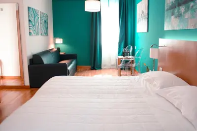 a bedroom with a large white bed and a couch at Principe Alogna Hotel & SPA in Altavilla Milicia
