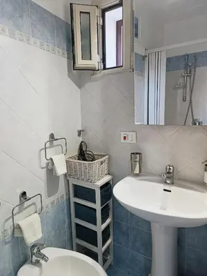 a bathroom with a sink and a toilet and a mirror at Da Mari e Paolo in Palermo