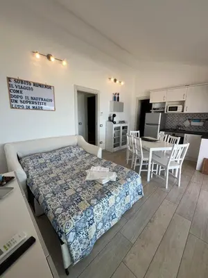 a bedroom with a bed and a table and chairs at Villa Futura in Scopello