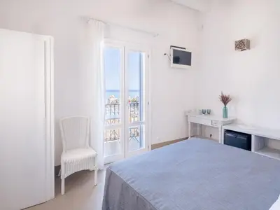a white bedroom with a bed and a window at Tannur B&B in Castellammare del Golfo