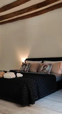 a black bed with pillows on it in a room at Cesare Home in Palermo