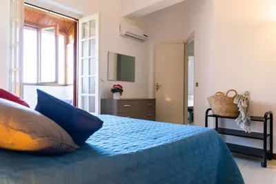 a bedroom with a bed with blue pillows at Casa Pitea in Mondello