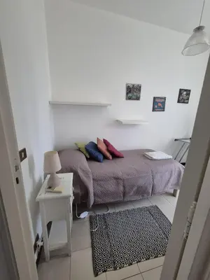 a small bedroom with a bed with pillows on it at Casa Pitea in Mondello