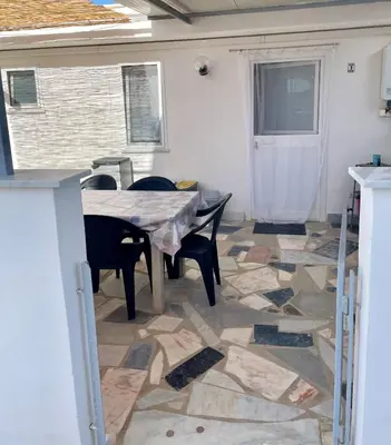 a patio with a table and chairs on a tiled floor at VILLA MOGUNTIA in Ficarazzi