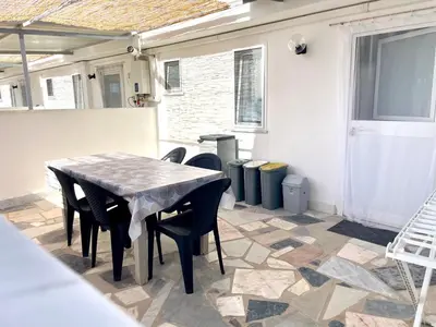 a patio with a table and chairs on a tile floor at VILLA MOGUNTIA in Ficarazzi