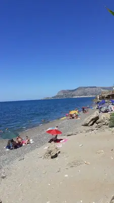 a group of people on a beach with umbrellas at VILLA MOGUNTIA in Ficarazzi