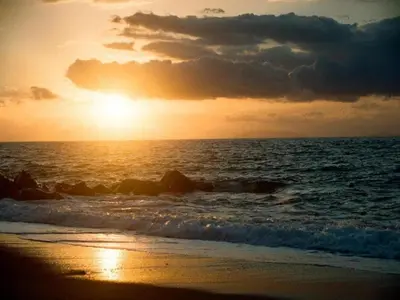 a sunset on the beach with the ocean at Villa with Pool, Pets & WiFi in Misilmeri