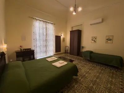 a living room with a green bed and a window at B&B Liberty in Palermo