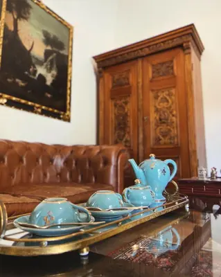 a living room with a couch and a tea set on a table at Villa del Gattopardo in Palermo