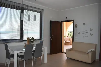 a dining room with a table and chairs and a door at In Riva al Mare da Franca in Trabia