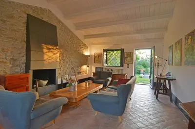 a living room with couches and a table and a fireplace at Villa con piscina vicino Cefalù (Sanificata) in Gratteri