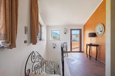 a hallway with a staircase and a clock on the wall at Panoramica Villa con Piscina sul Mare (Sanificata) in Cinisi