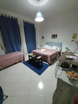 a living room with two beds and a table at Alba central City in Palermo