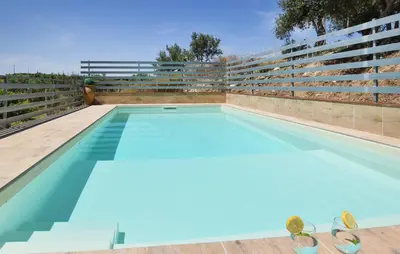 a large swimming pool with two chairs at Villa Trappeto in Trappeto