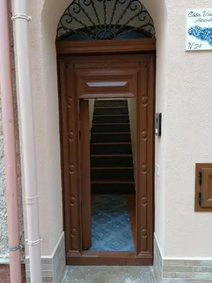 a wooden door leading to a staircase in a building at Case Vacanze Azzurra, Loredana e Trinacria in Castellammare del Golfo