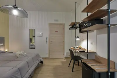 a bedroom with a bed and a desk and a table at Meridiana B&B in Palermo