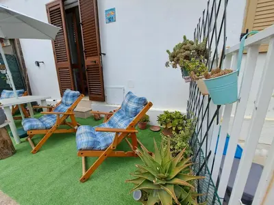 a patio with two chairs and a fence with plants at Bea's House in Castellammare del Golfo