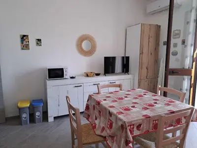 a kitchen with a table with chairs and a refrigerator at Bea's House in Castellammare del Golfo