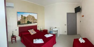 a small bedroom with a red bed and a table at Palermo City Room in Palermo