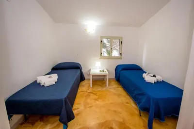 a room with two beds and a small table at Casa Contrada Molinello in Castellammare del Golfo
