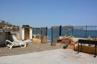 a patio with a chair and a view of the ocean at Villa Silvia by Ville in Palermo in Casteldaccia