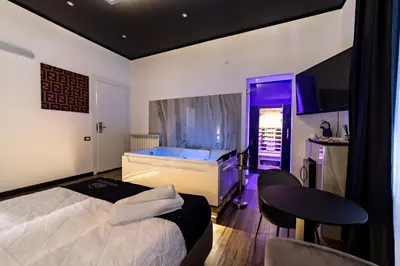 a bedroom with a bed and a tub and a table at Maximum Suite & Spa in Palermo