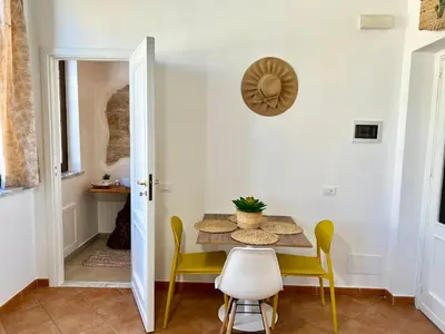 a dining room with a table and yellow chairs at da Mumminedda in Cinisi
