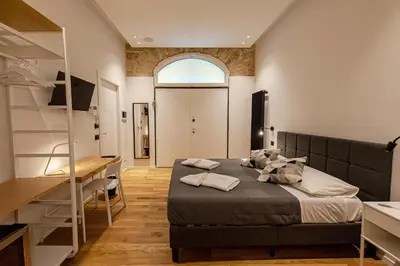 a bedroom with a bed and a desk in a room at Palazzo al Carmine in Monreale