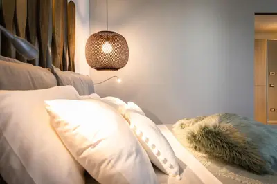 a bedroom with a bed with white pillows and a lamp at NESOS SUITE by DomuSicily in Mondello