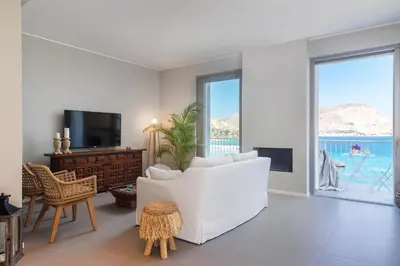 a living room with a white couch and a tv at NESOS SUITE by DomuSicily in Mondello
