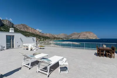 a patio with chairs and a view of the ocean at NESOS SUITE by DomuSicily in Mondello