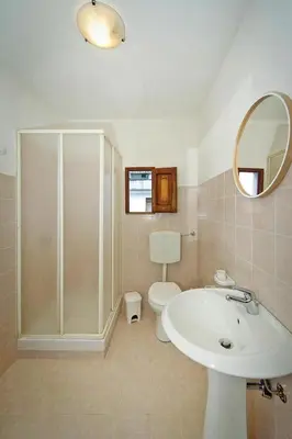 a bathroom with a sink and a toilet and a mirror at Apartment, Castellammare del Golfo in Castellammare del Golfo