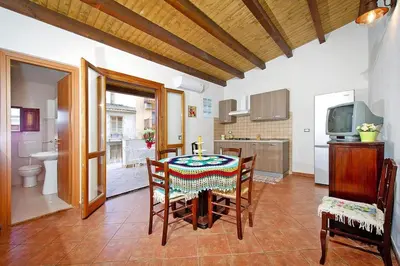 a dining room with a table with a candle on it at Apartment, Castellammare del Golfo in Castellammare del Golfo