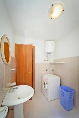 a bathroom with a sink and a washing machine at Apartment, Castellammare del Golfo in Castellammare del Golfo
