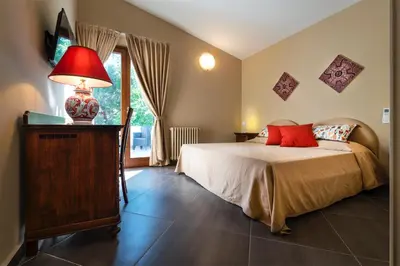 a bedroom with a bed with a red lamp on a table at Villa San Lorenzo in Palermo