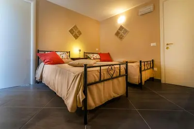 a bedroom with two beds with red pillows at Villa San Lorenzo in Palermo