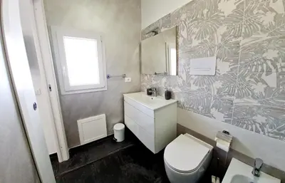 a bathroom with a toilet and a sink and a mirror at SCRUSCIU HOME in Terrasini