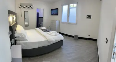 a bedroom with a large bed and a mirror at LA CASA DELLE FATE-Area Marina Protetta in Isola delle Femmine