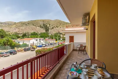 a table on a balcony with a view of a street at Mondello Sabrina Apartments in Mondello